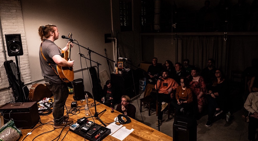 Braedan Coghlan playing solo acoustic to a full seated room